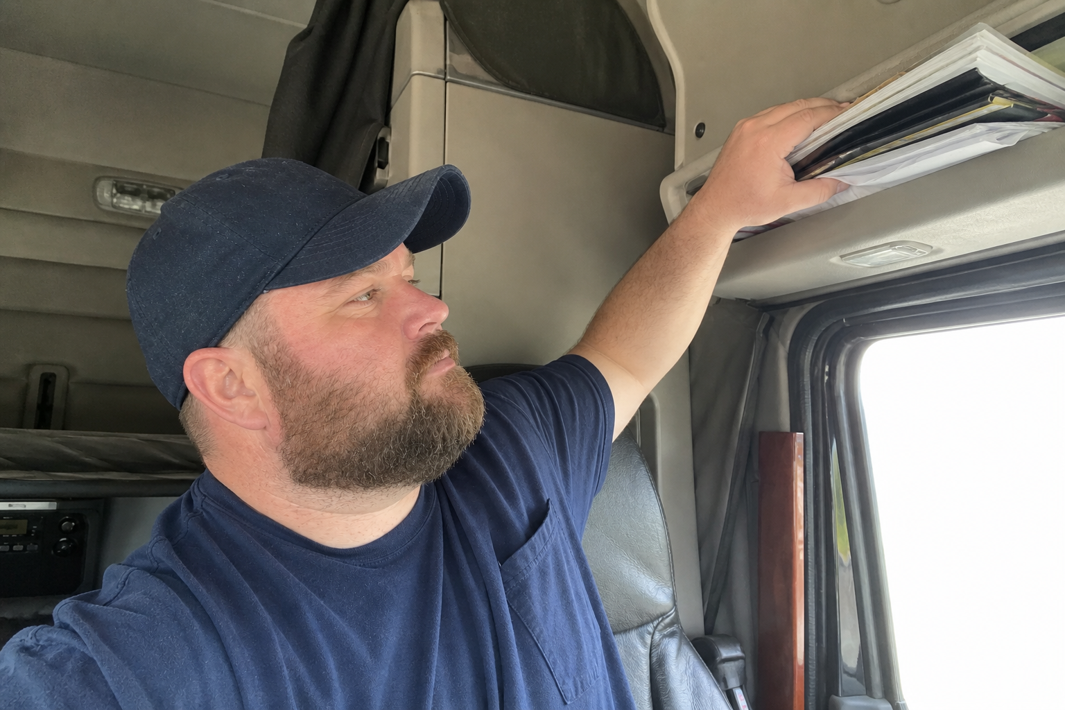 Garrett organizing paperwork in a parked truck cab